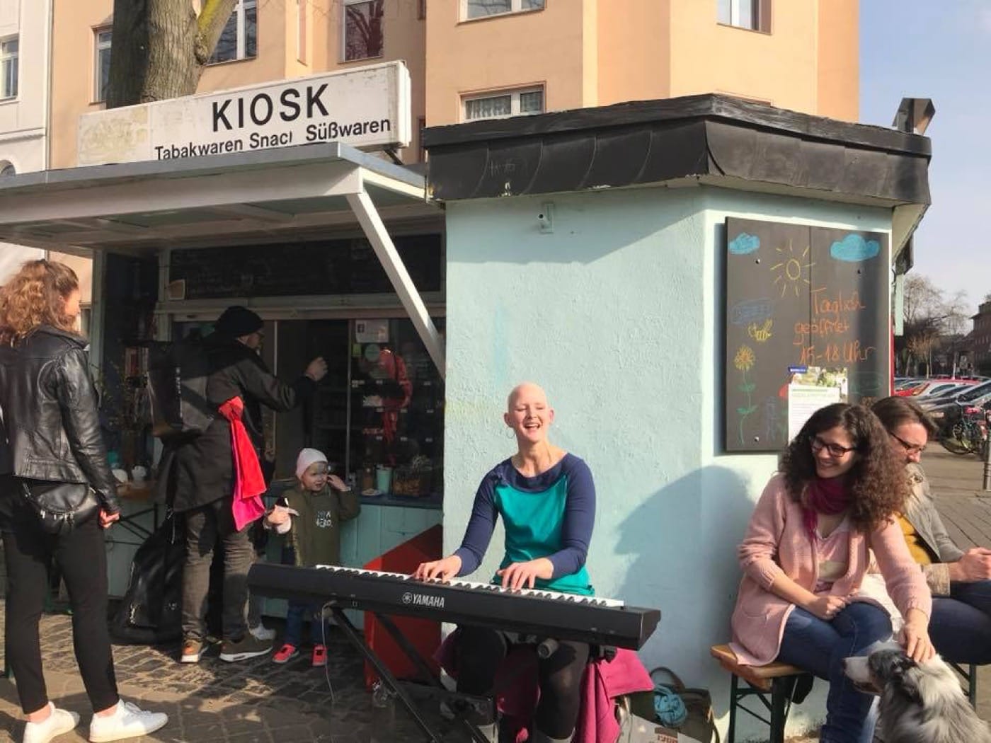 Singer-Songwriterin Dino spielt Keyboard vor dem Büdchen am Nikolausplatz in Köln