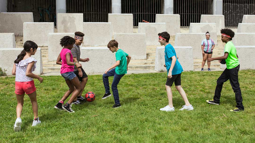Kinder und Jugendliche spielen gemeinsam Fußball.